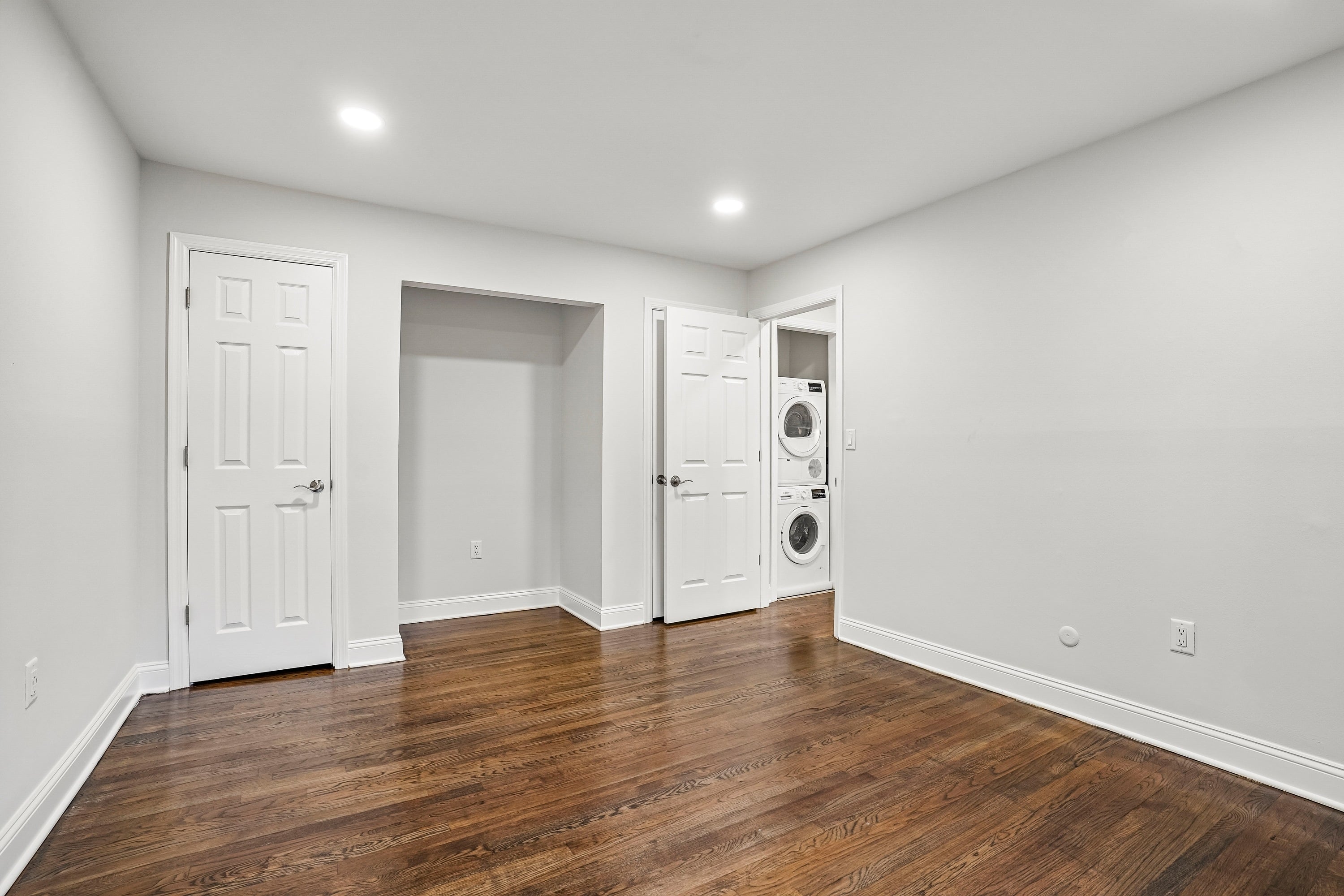 A room with a wooden floor and white walls.